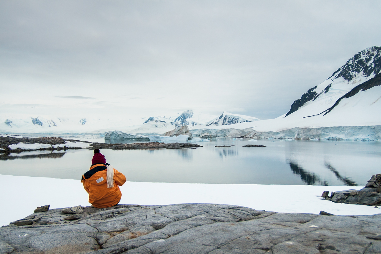 Marie Knock takes time to enjoy the view of icebergs and gentoo penguins in Dorian Bay, Antarctica.